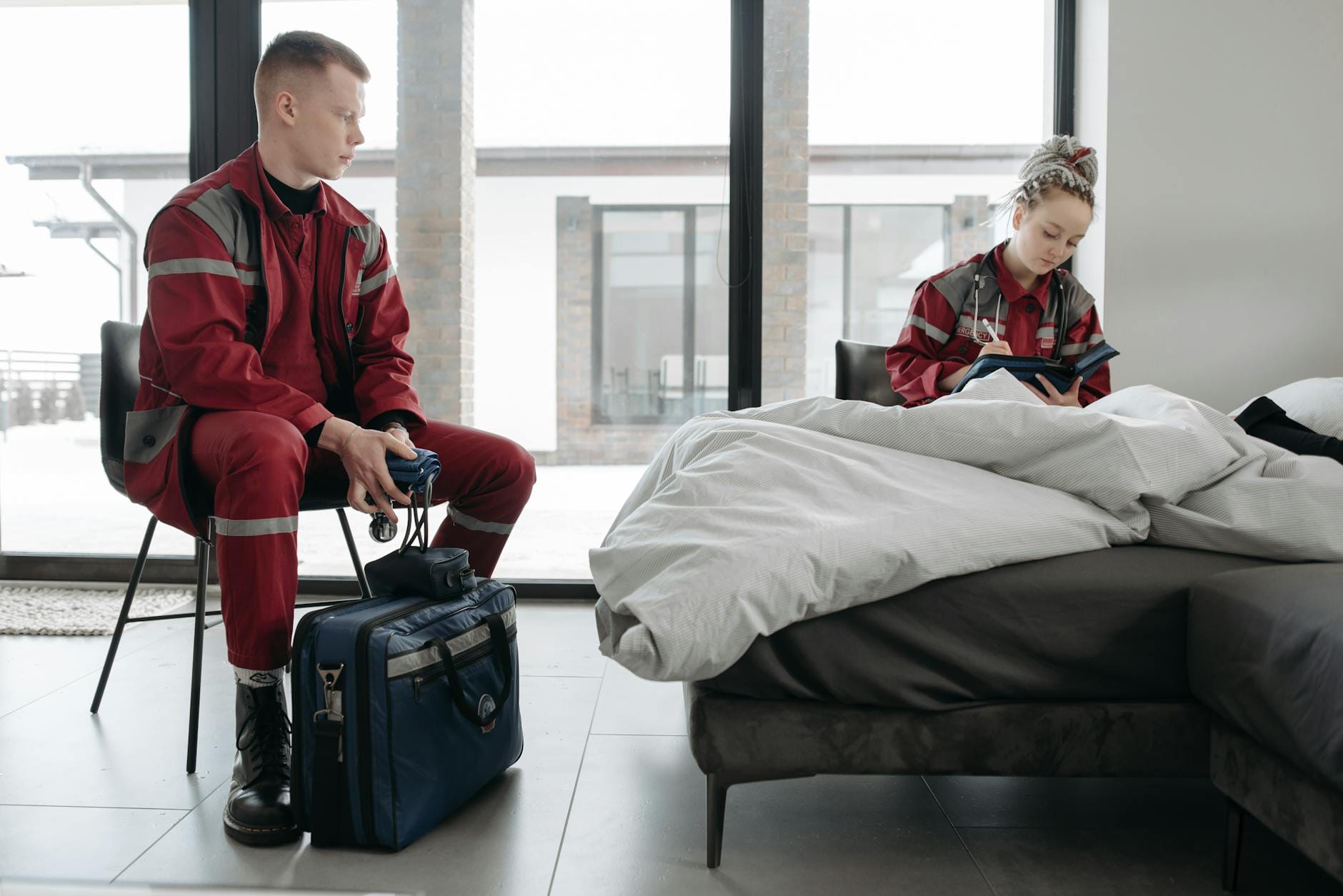 Ratownicy medyczni udzielają pomocy pacjentowi w nowoczesnej sypialni